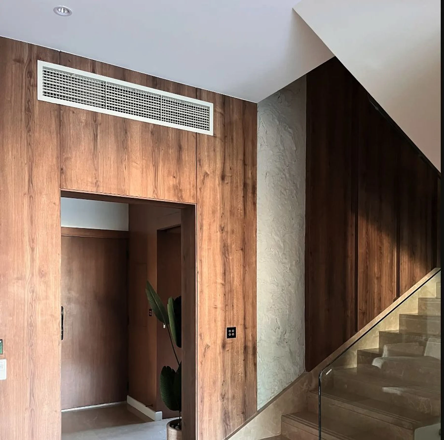 A timber-lined threshold tying the entry to the stair.