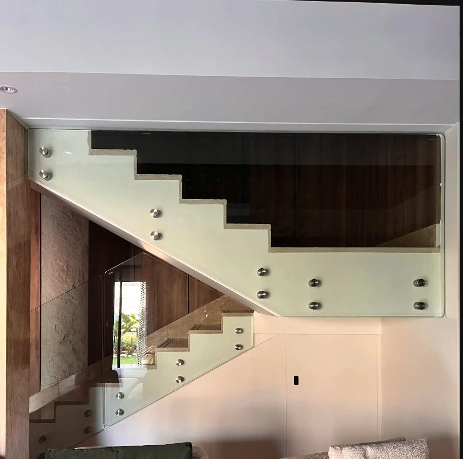 A stair flight framed by glass, timber and precise shadow gaps.