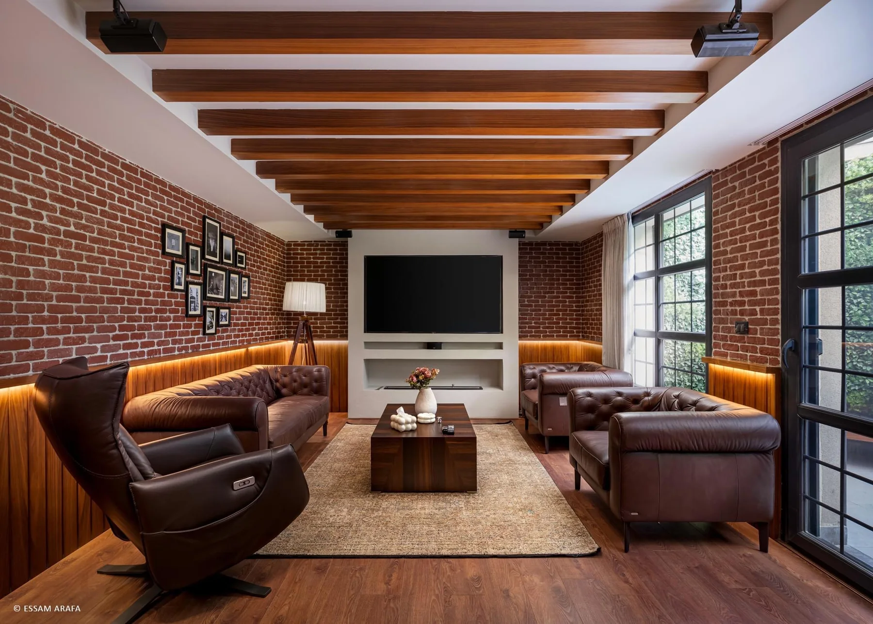 Living room with timber ceiling beams, brickwork and integrated media joinery