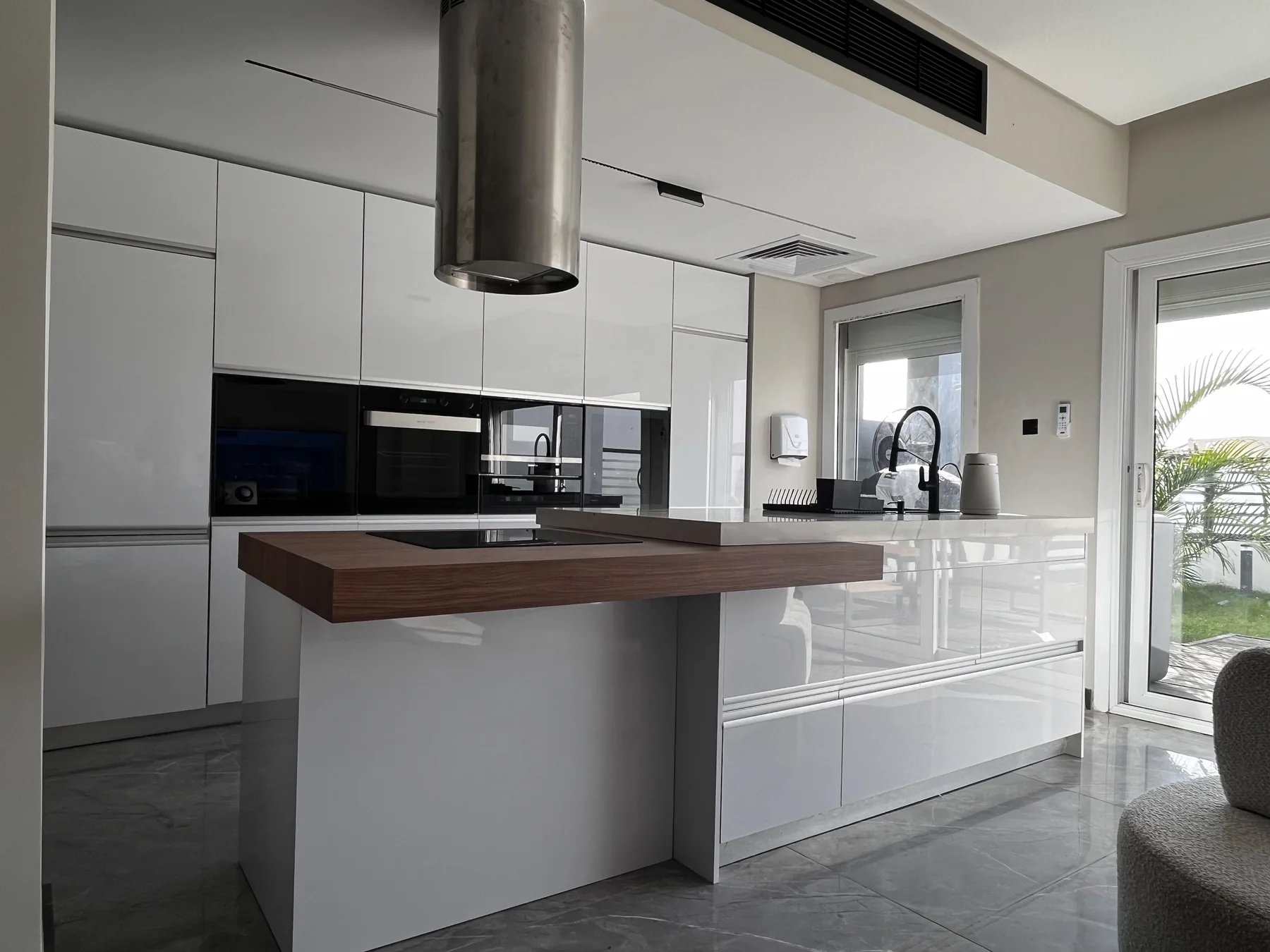 White kitchen islands with walnut work surfaces